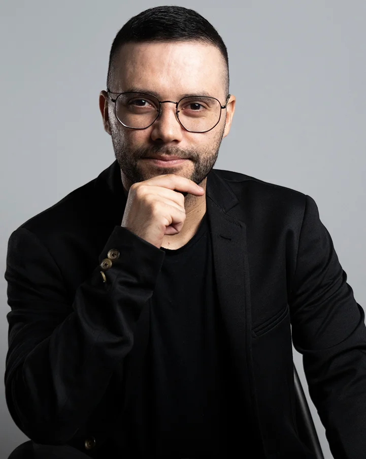 Nathan, CEO da Agência Pense D, de terno preto e óculos.